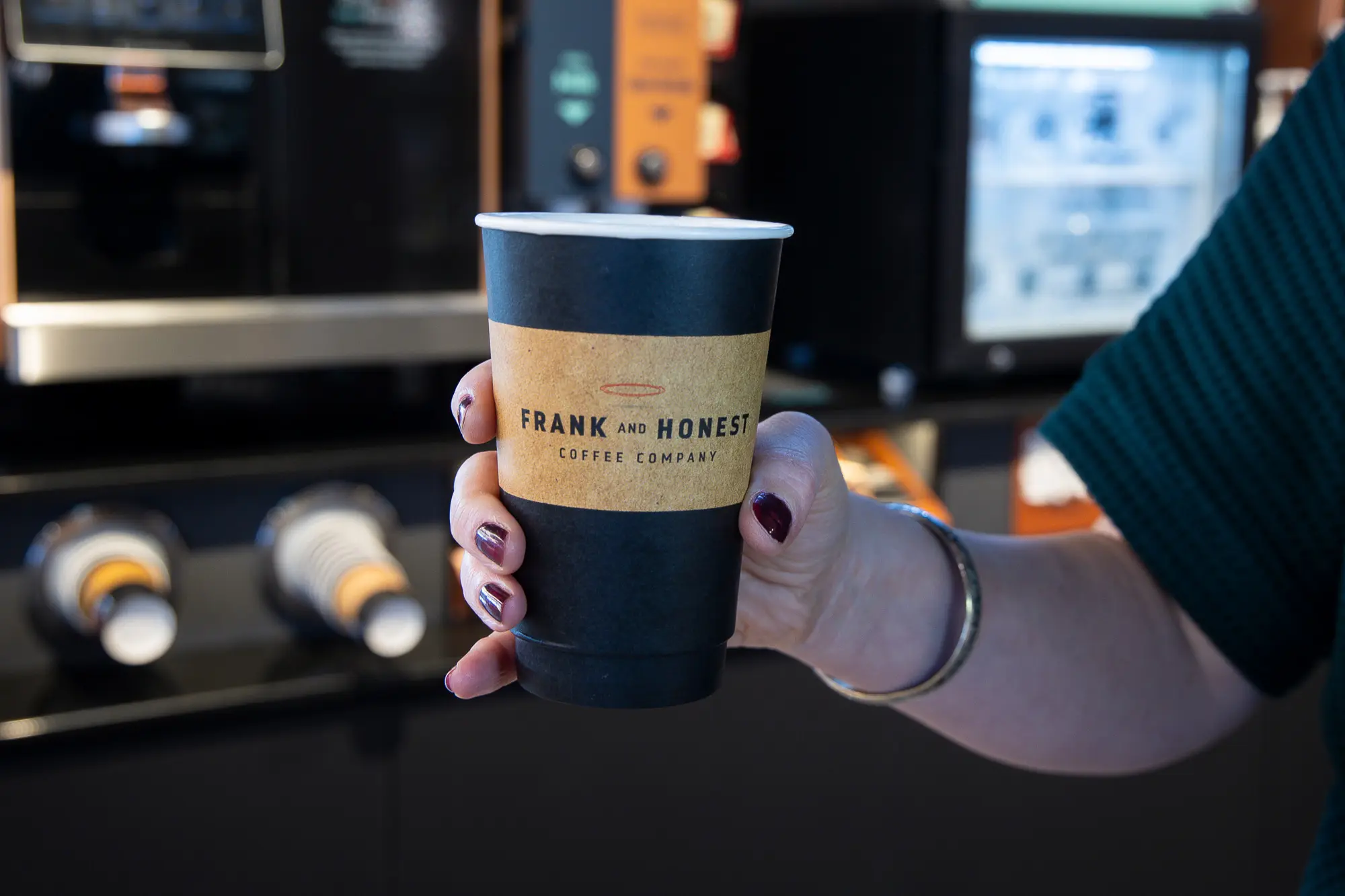 Close-up photo of a Frank and Honest takeaway paper coffee cup.